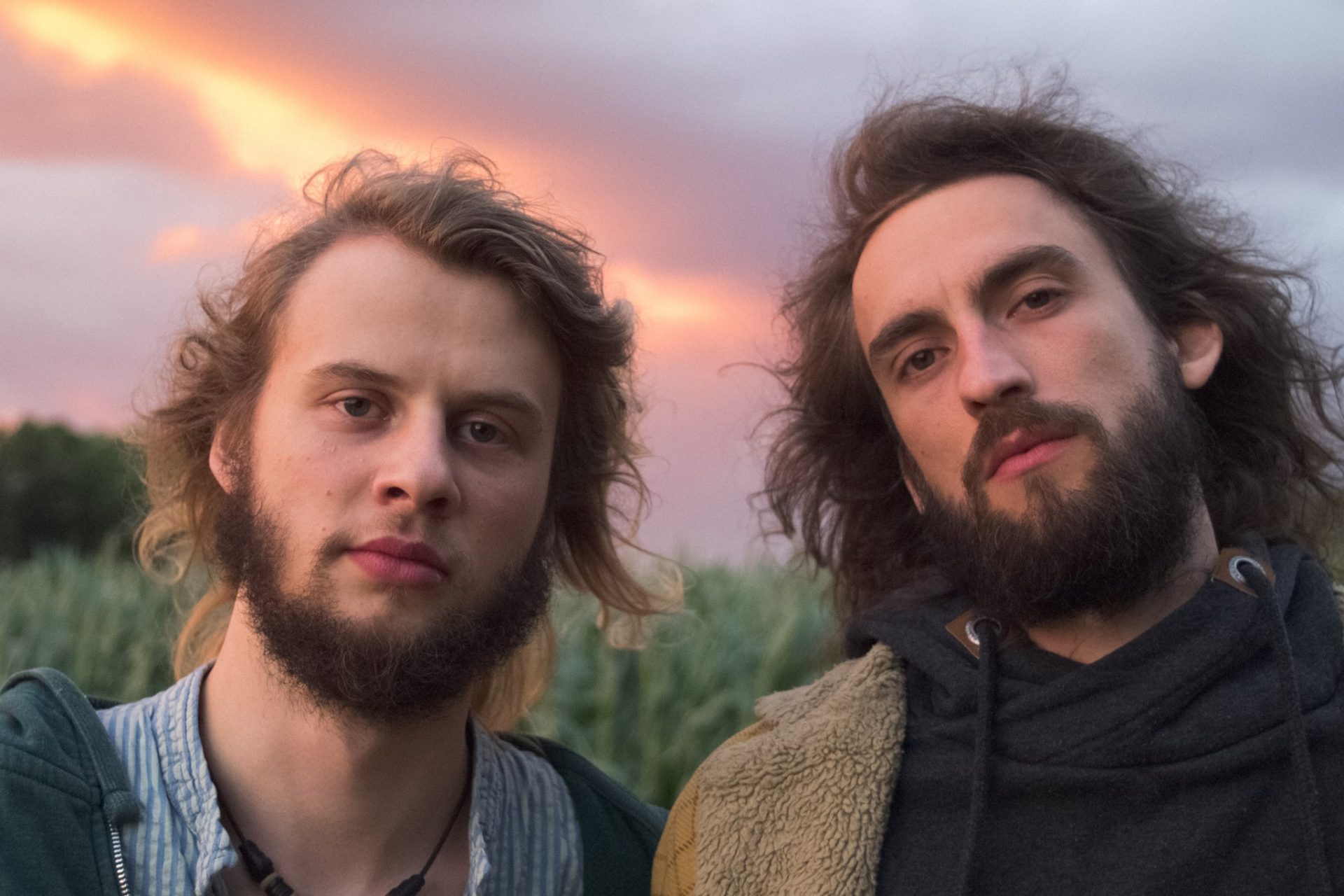 Gesichter von zwei Personen vor wolkigem Himmel